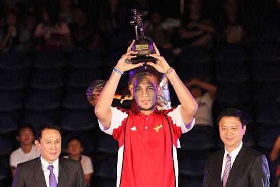 June Mar Fajardo holding a trophy | GGSLOT | Sports & Games News June Mar Fajardo holding a trophy, representing the top tier of PBA player earnings.