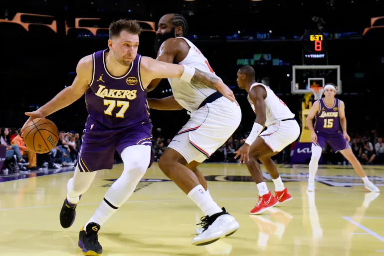 Luka Doncic bringing the ball up the court wearing the iconic purple and gold Los Angeles Lakers jersey.