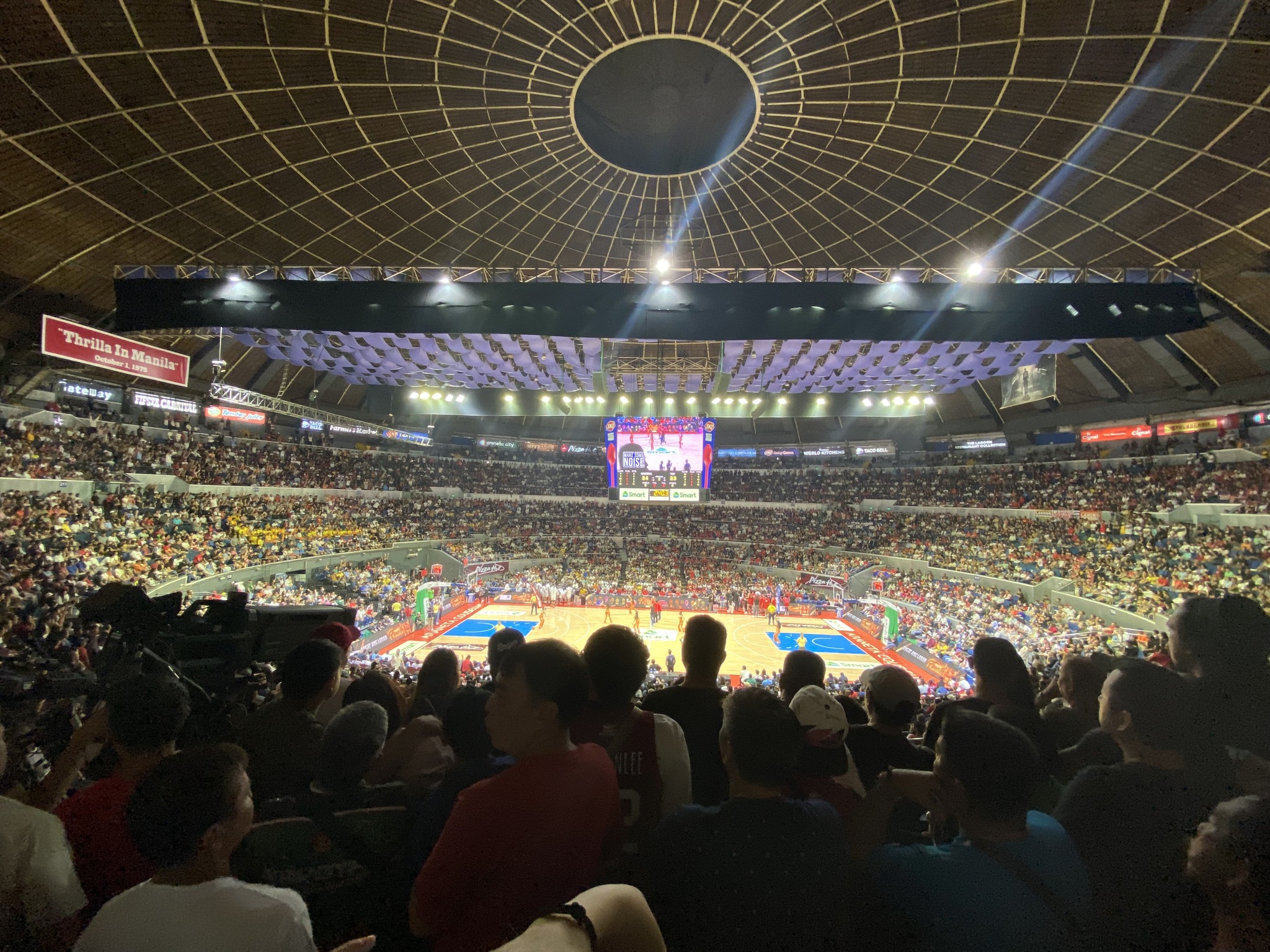 Enthusiastic fans packing the Araneta Coliseum for a high-stakes PBA game.