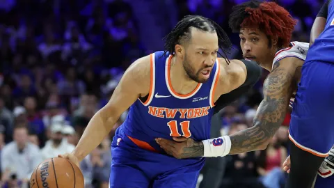 New York Knicks guard #11 dribbles the basketball while being closely defended on the court.