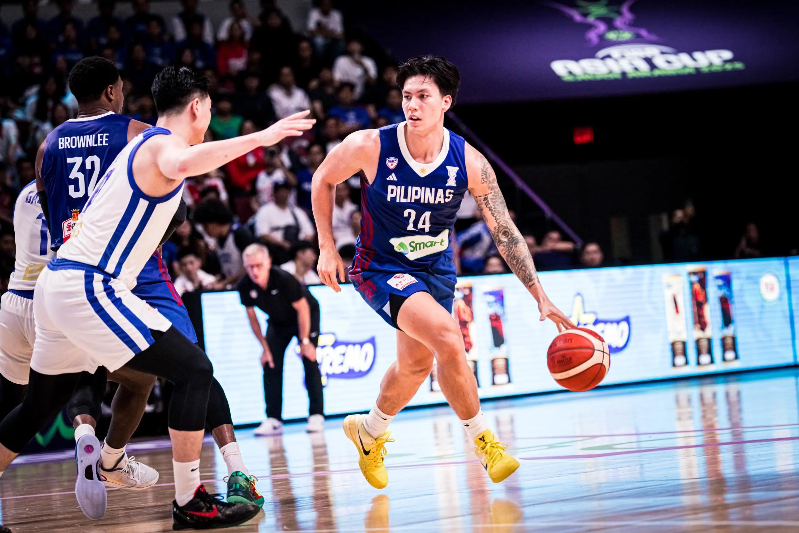 Dwight Ramos dribbling the basketball and scanning the court during a competitive game