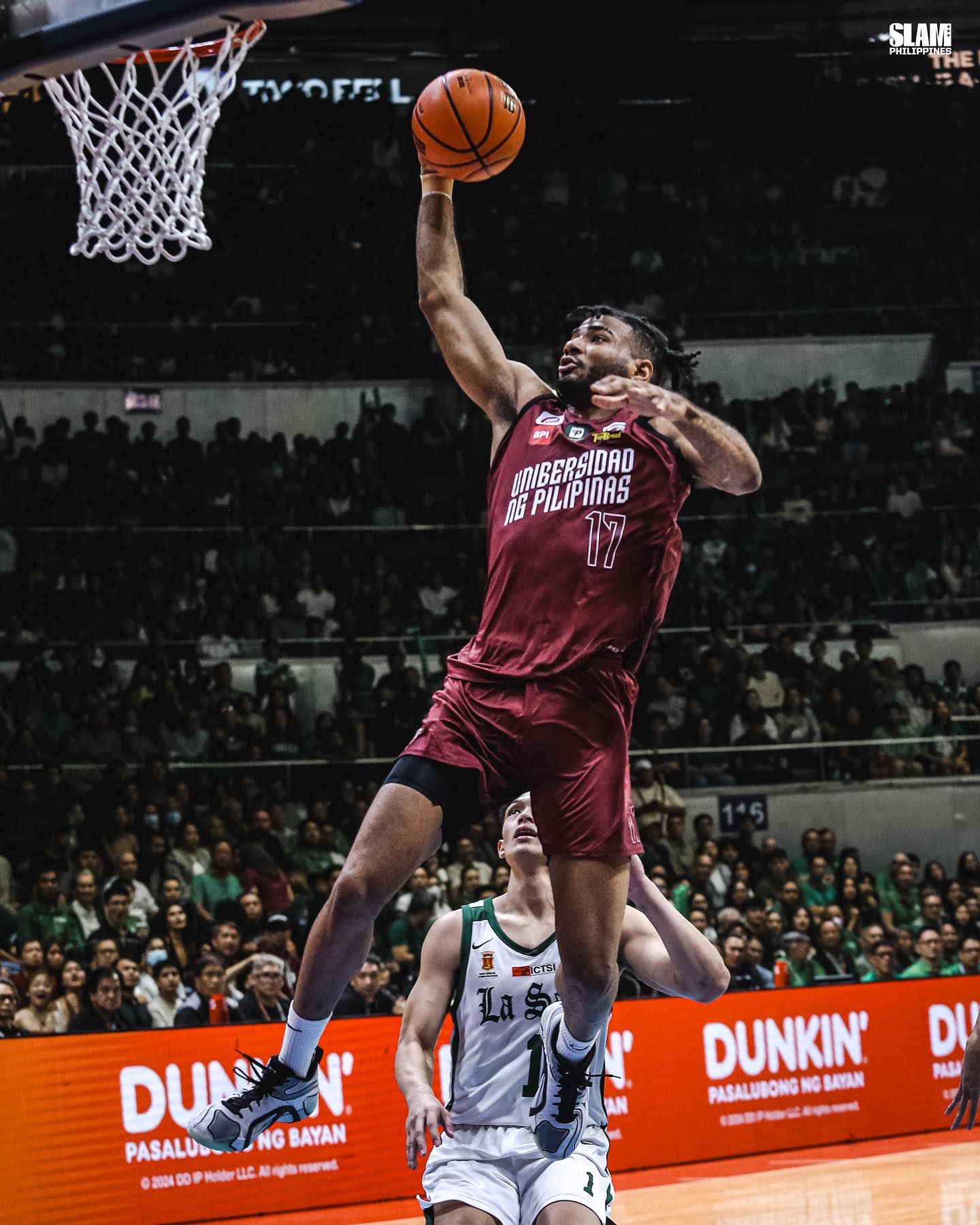 Francis Lopez of the UP Fighting Maroons soaring for a powerful slam dunk against a defender