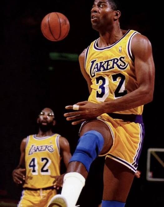 Action shot of Magic Johnson making a no-look pass