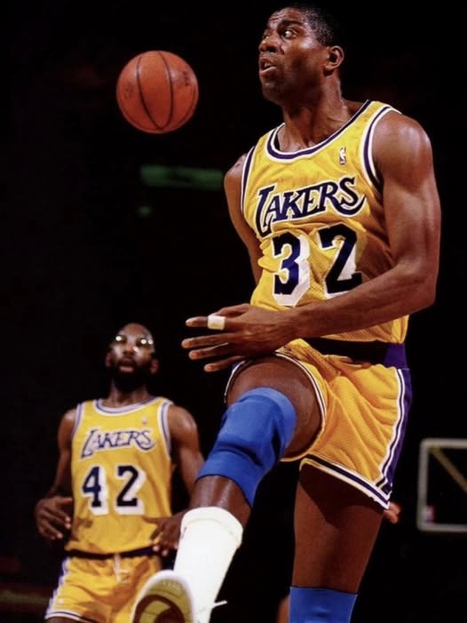Action shot of Magic Johnson making a no-look pass