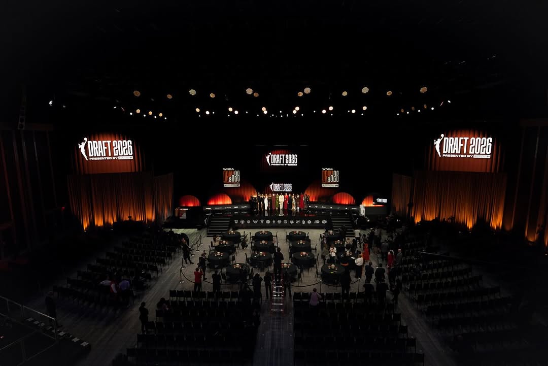 The official basketball draft stage illuminated with bright lights, ready to welcome the new rookie class.