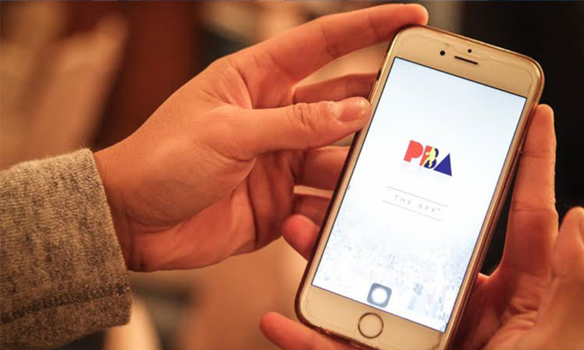 pba-live-updates-mobile | GGSLOT | Sports & Games News A basketball fan using a smartphone to check live scores and updates during a PBA game