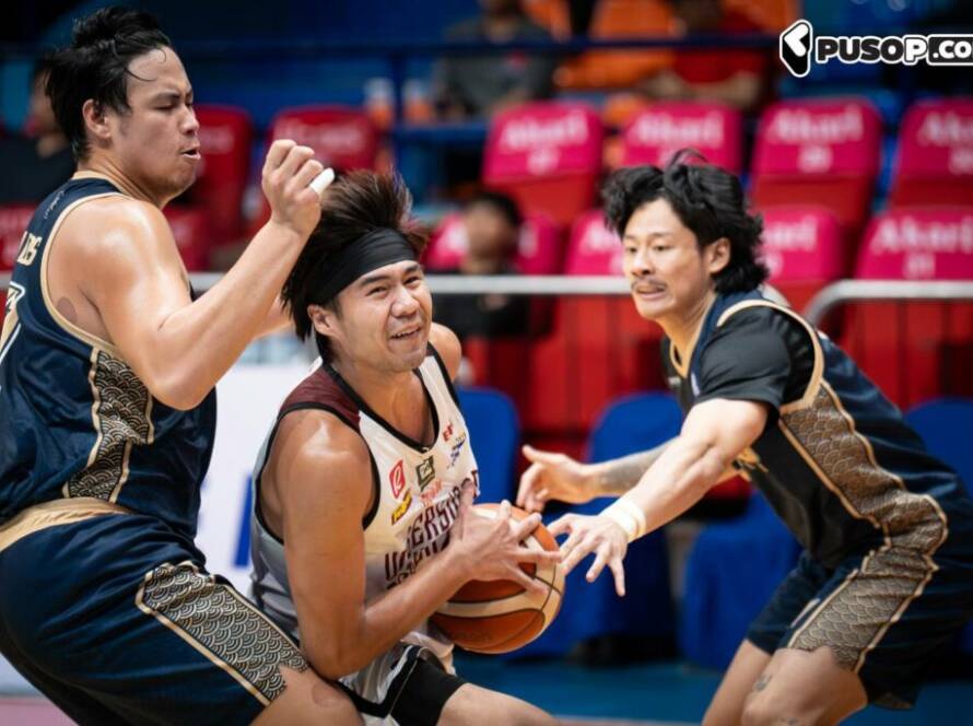 Basketball player in white attempts to drive with the ball while two defenders reach in from the sides in a crowded court scene.