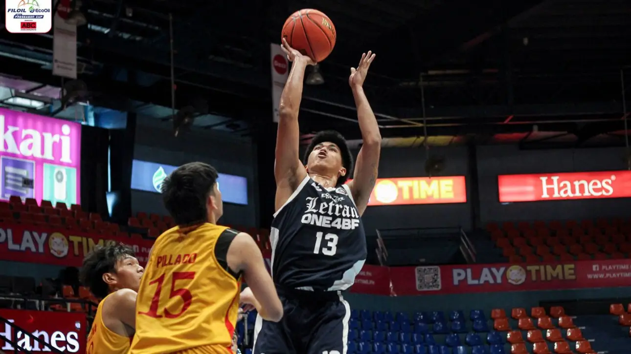 Basketball player in navy jersey #13 jumps to shoot, while defenders in yellow try to block in a crowded indoor arena with sponsor banners like PLAY TIME and Hanes.