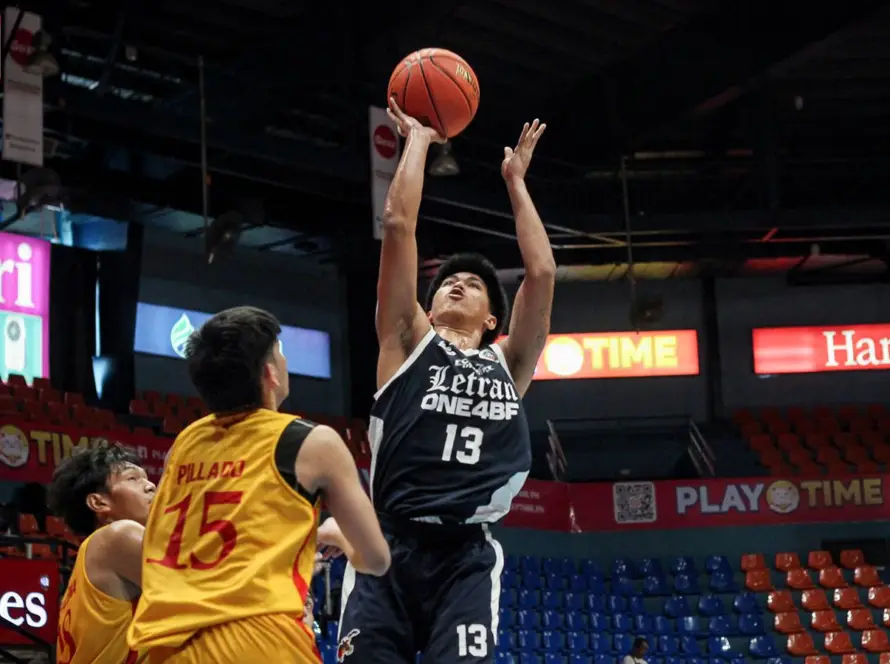 Basketball player in navy jersey #13 jumps to shoot, while defenders in yellow try to block in a crowded indoor arena with sponsor banners like PLAY TIME and Hanes.