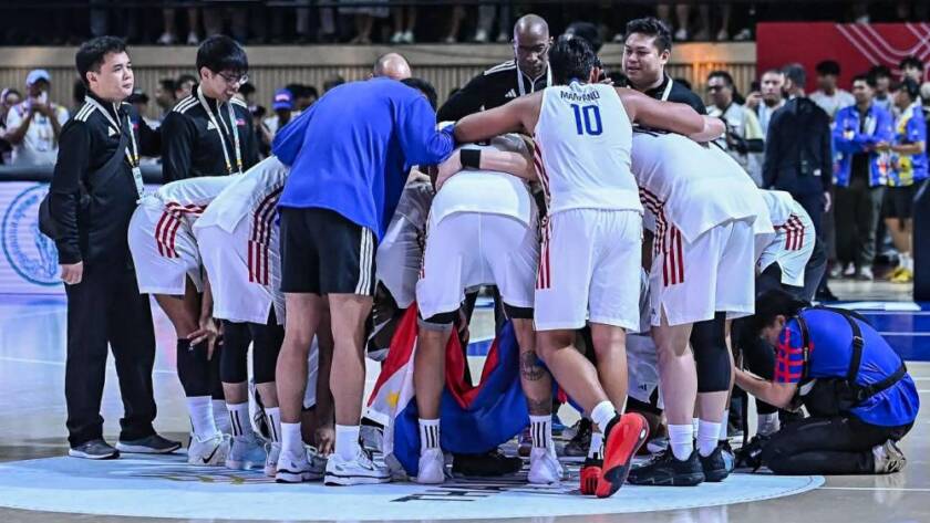 The Philippine men's national basketball team huddling during a timeout on the court.