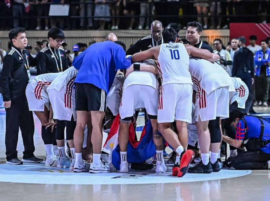 The Philippine men's national basketball team huddling during a timeout on the court.