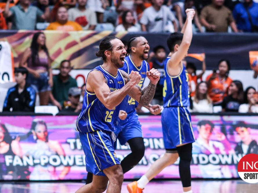 Basketball players in blue uniforms celebrate onscreen as the crowd cheers in the stands behind them.