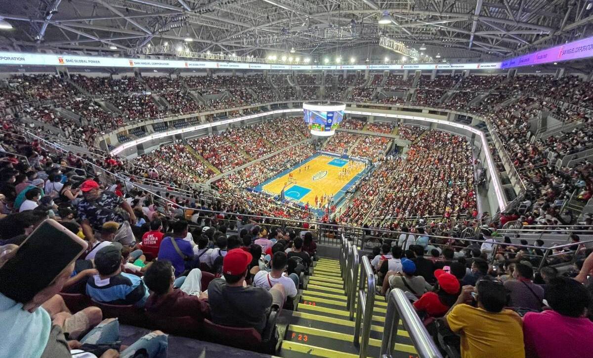Overhead view of a packed basketball arena with a game in progress on the court.