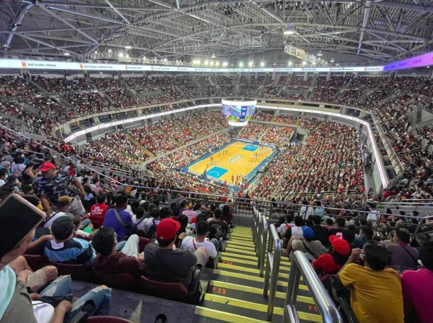 Overhead view of a packed basketball arena with a game in progress on the court.