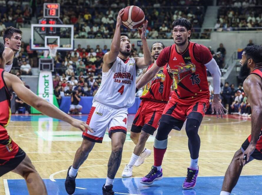 An intense defensive play on a professional indoor basketball court, showing a defender leaping to contest a shot at the rim.
