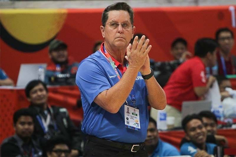 tim-cone-coaching | GGSLOT | Sports & Games News Male sports official in a blue polo clapping at a crowded event, with event badge on a lanyard visible