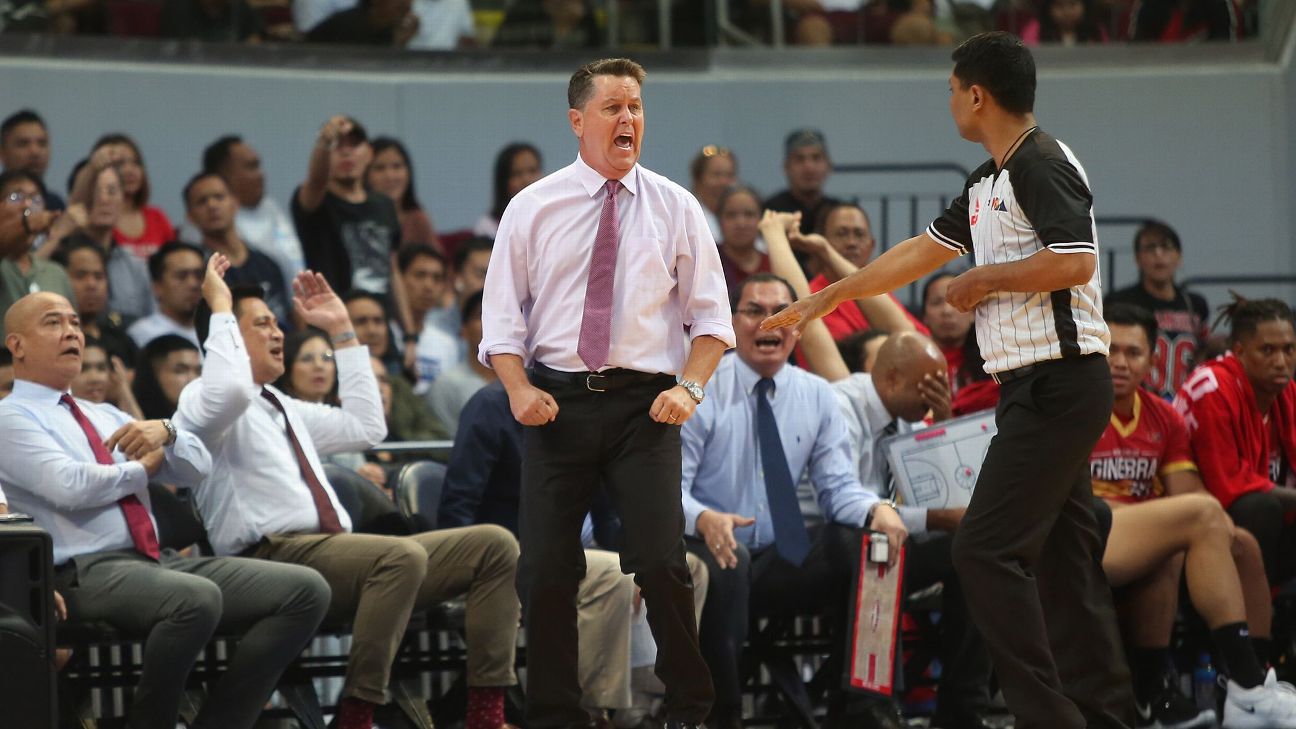 coach-tim-cone-defensive-drills | GGSLOT | Sports & Games News Coach Tim Cone leading a stretching and defensive practice drill on an indoor basketball court.