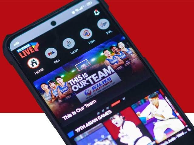 Smartphone screen tilted on a red background, showing a basketball app interface with a 'THIS IS OUR TEAM' banner and team photos.