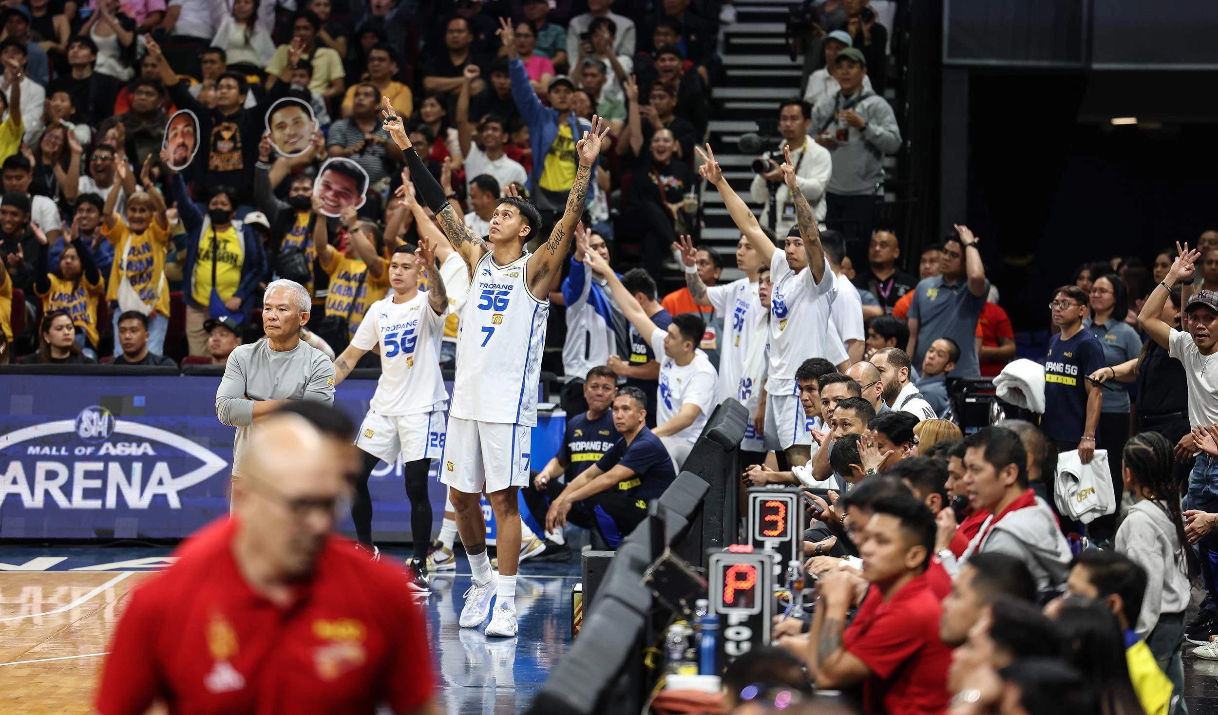 Filipino basketball fans cheering during a PBA game