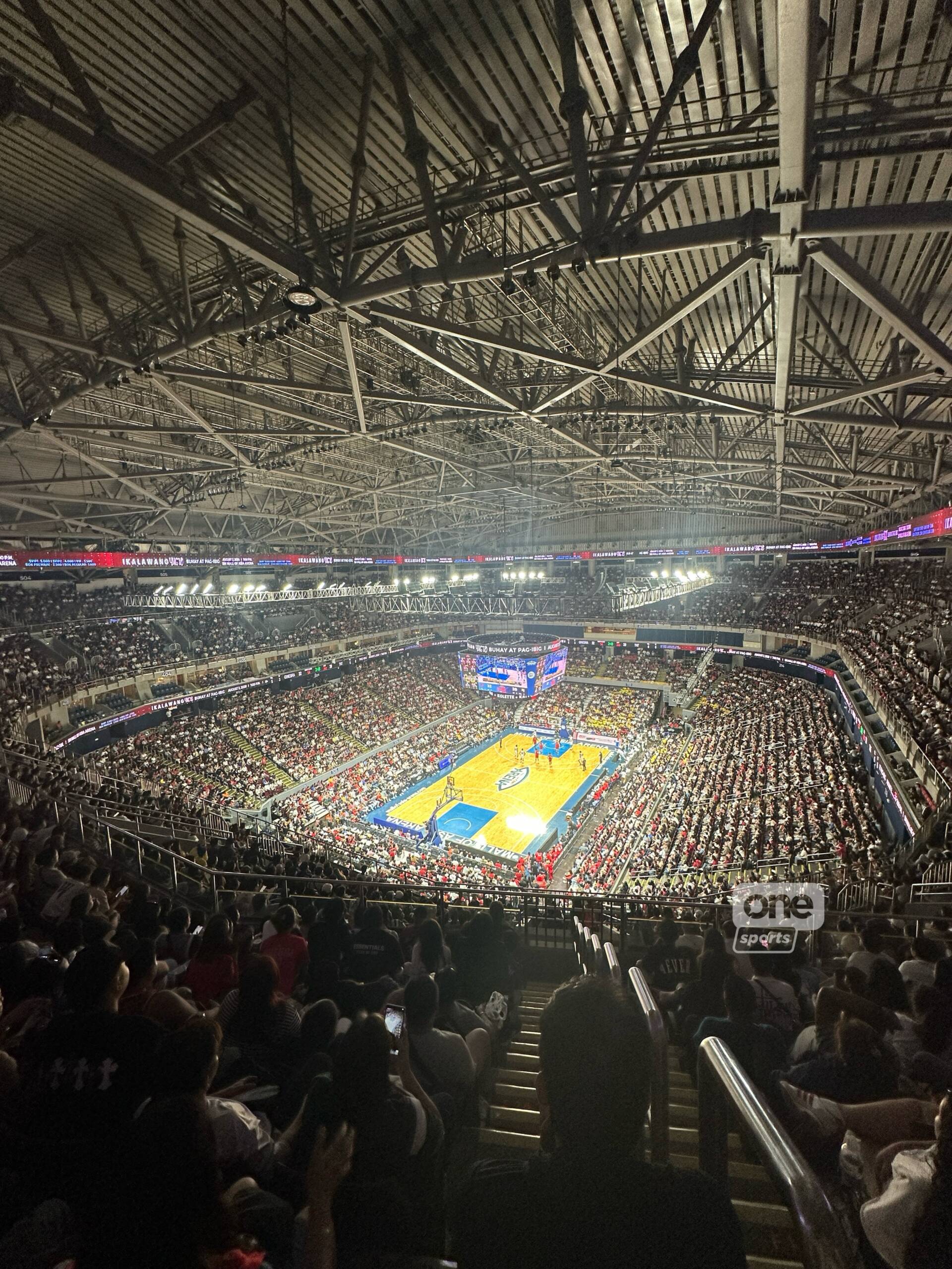 pba-governors-cup-championship-arena | GGSLOT | Sports & Games News Wide shot of a packed basketball arena, viewed from the upper stands, with a lit court and audience surrounding it.